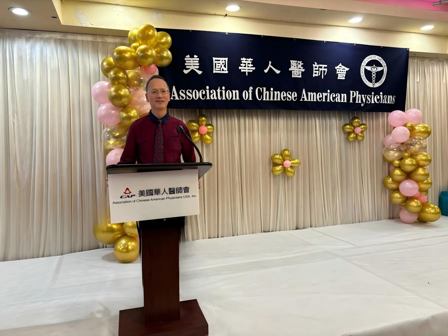 Dr. Lee speaking at the podium of the Association of Chinese American Physicians