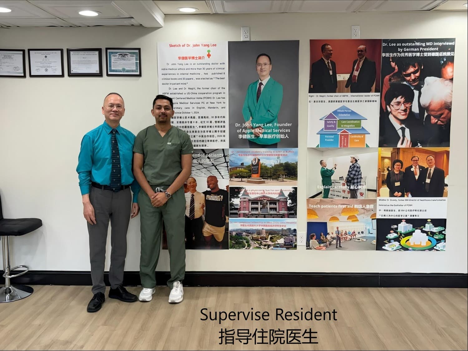 Dr. Lee standing with a resident physician in green scrubs in front of a poster wall
